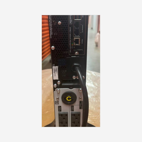 Actual APC SRT2200XLA UPS rear view with installed AP9631 card; OEM nominal tower chassis 17.01 H × 3.35 W × 22.99 D in; physical measurement unverified