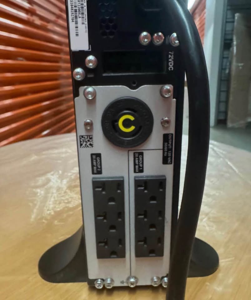 Original close view of the APC SRT2200XLA rear outlets, attached cord and tower foot