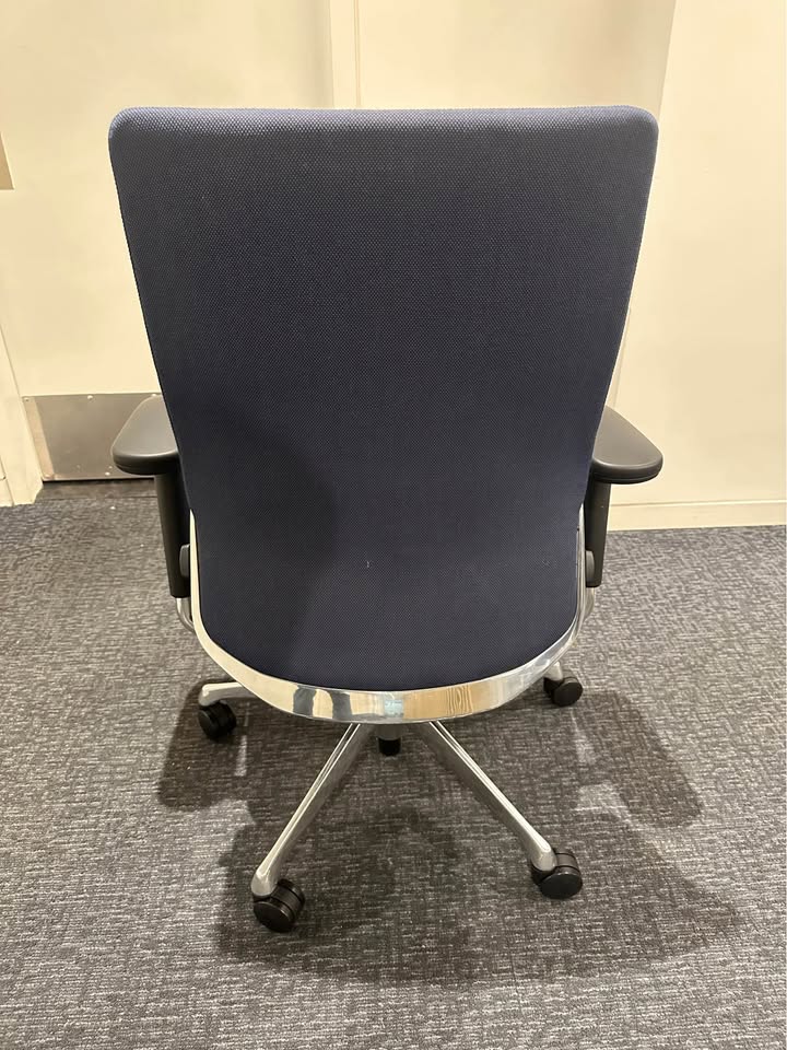 Actual blue upholstered rolling office chair — rear view