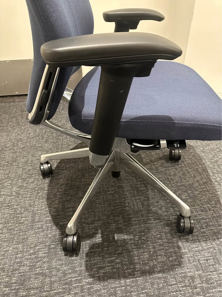 Actual blue upholstered rolling office chair — right side and armrest detail