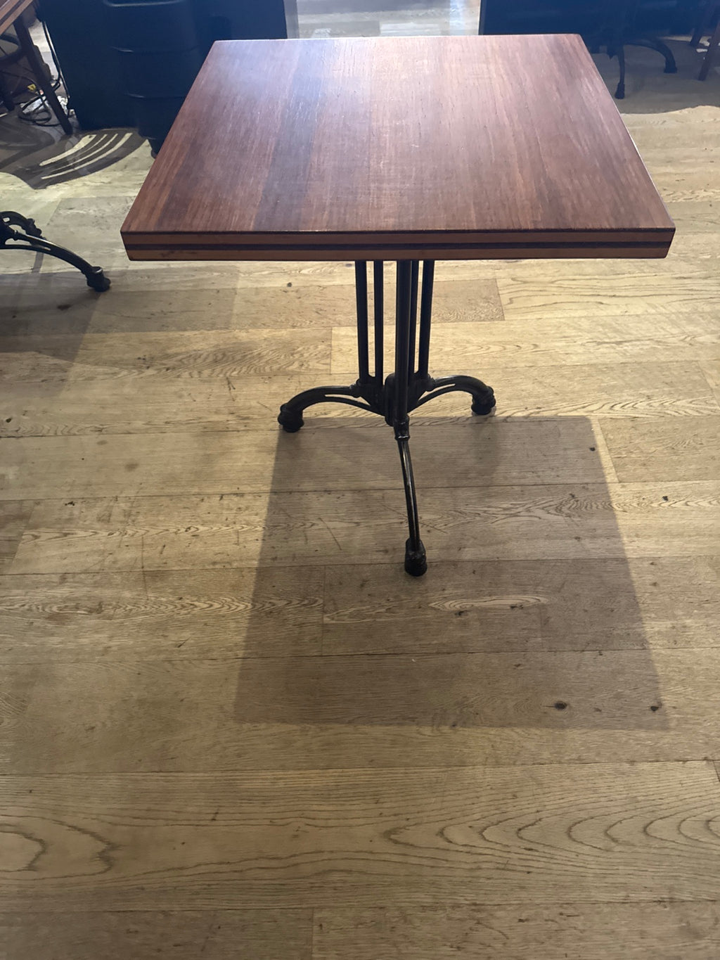 Original owner photo of wood-top bistro table and black metal pedestal.